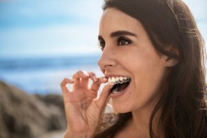 Woman inserting Invisalign aligners