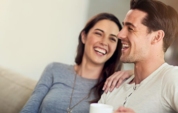Man and Women with overbite laughing with a cup of tea in hand