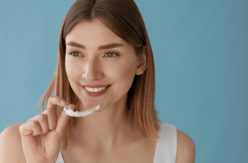 Woman putting in Invisalign braces in Wolverhampton dental practice