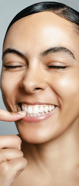woman with Invisalign braces biting down on nail at Wolverhampton dental practice