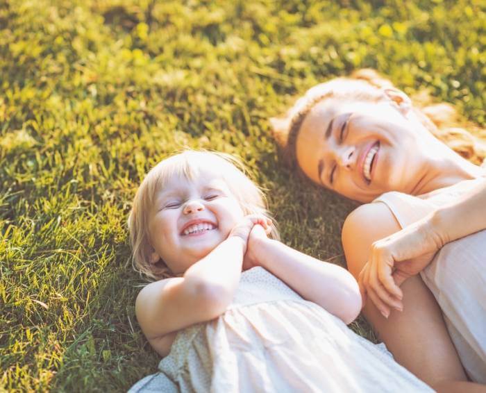 woman and daughter laughing on the floor after visiting claregate dental