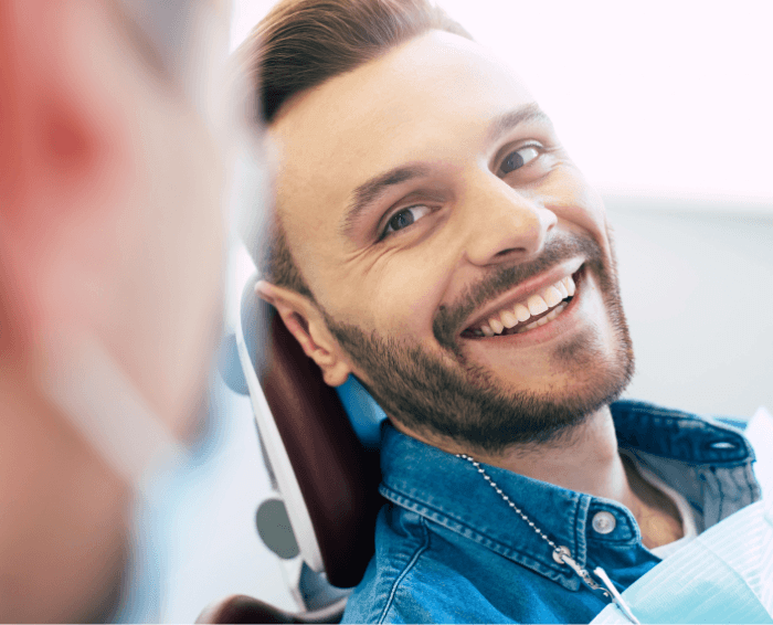 Man smiling in dental chair after dental anxiety treatment